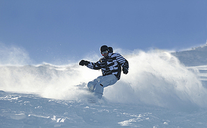 freestyle snowboarder jump and ride free style  at sunny winter day on mountain