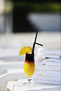 coctail dring with orange att sunny day on swimming pool side with white towel decoraton