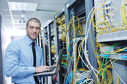 young engeneer business man with thin modern aluminium laptop in network server room