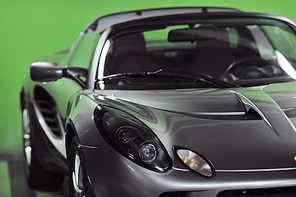 detail of sport silver car with green background