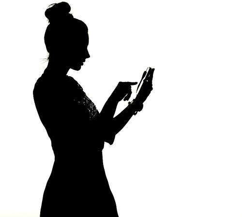 Silhouette of a lady uisng the smartphone
