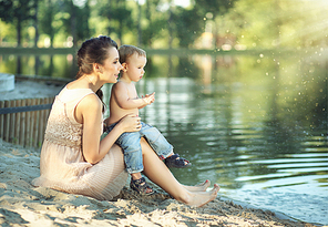 Mom with son looking at the calm lake