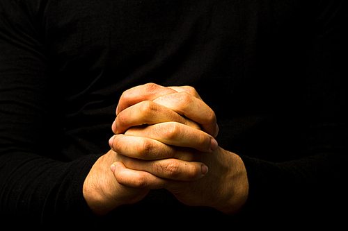 Young man’s hands in prayer