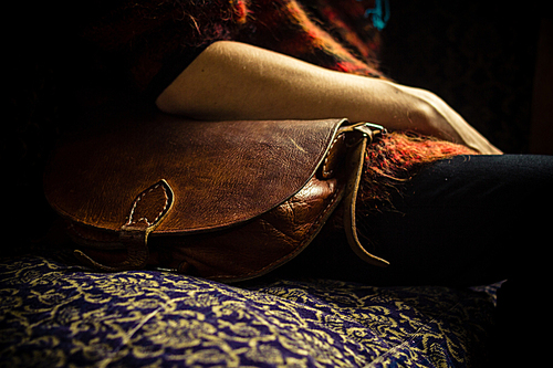 Woman with bag sitting on sofa