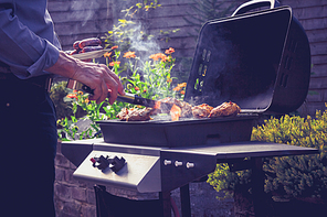Man cooking meat on barbecue