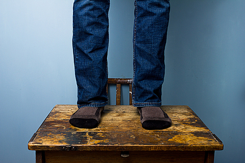 The feet of a man standing on a desk