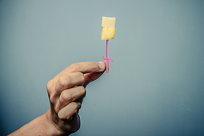 Hand holding toothpick with pineapple