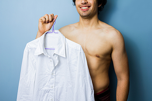 Young man holding a white shirt