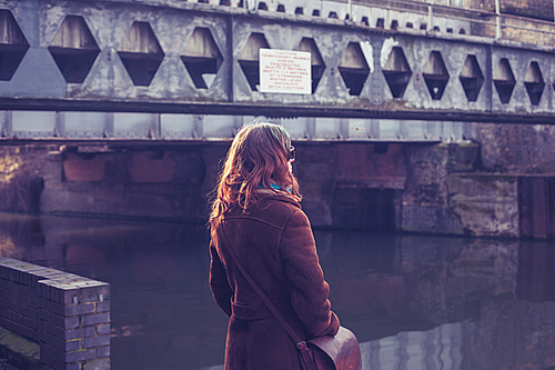 Young woman standing by canal