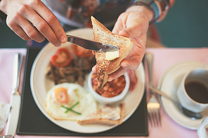 Closeup on a young woman’s hands as she is having breakfast