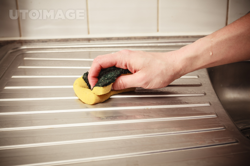 유토이미지 | The hand of a young woman is cleaning around the kitchen sink