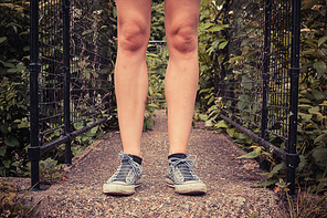 Close up on the legs of a young woman as she is standing outside in nature on a spring day