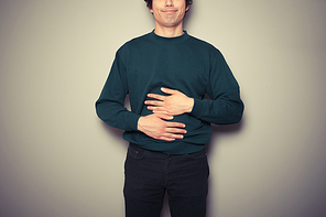 A young man is rubbing his stomach