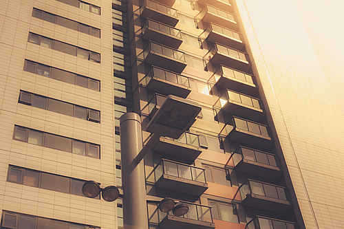 An apartment block and a stret lamp at sunset