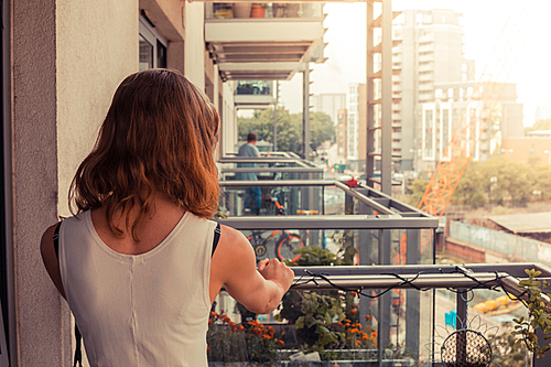 A young woman is relaxing on her balcony on a sunny day