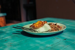 An asian dish on a blue table in a restaurant in the sunlight