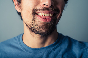 A young man with a beard is pulling silly faces