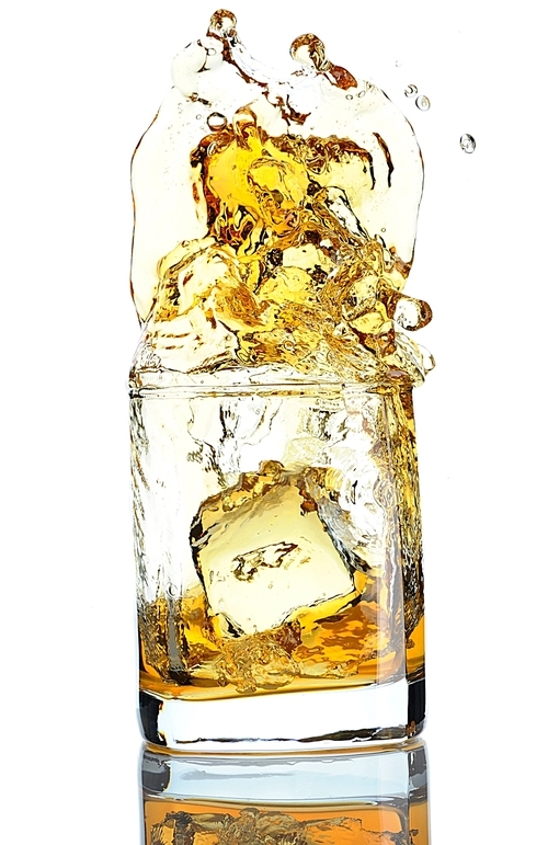 Ice cube splashing in scotch isolated on white