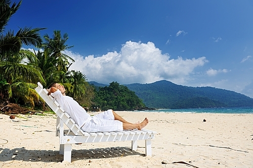 Man in white relaxing on a tropical beach