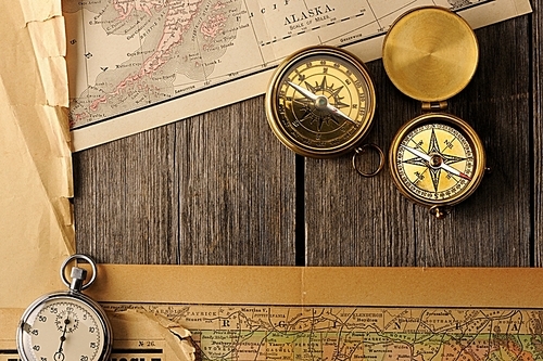 Antique brass compasses over old map