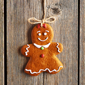 Christmas homemade gingerbread girl over wooden background