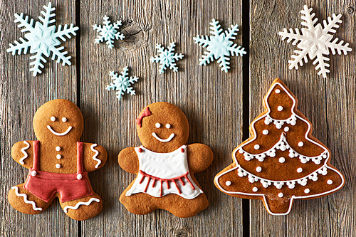 Christmas homemade gingerbread couple and tree on wooden table