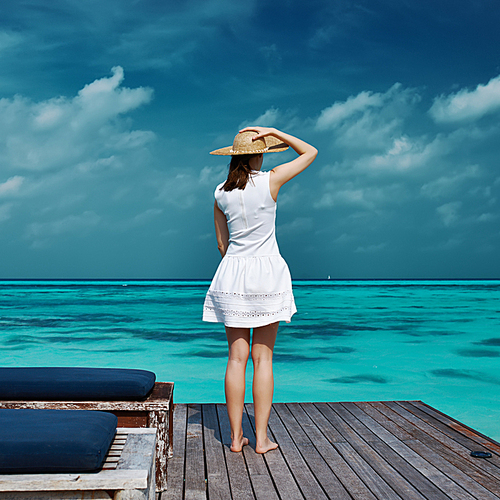 Woman on a tropical beach jetty at Maldives