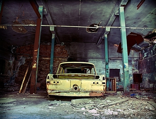old ruined garage interior with old car