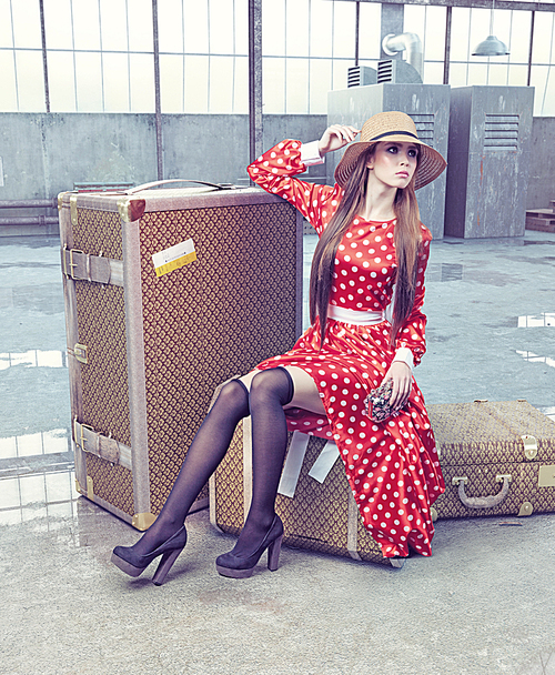 girl sitting on a suitcase waiting for travel