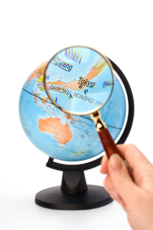 Japan map. Hand holding magnifying glass over earth globe Japan territory.