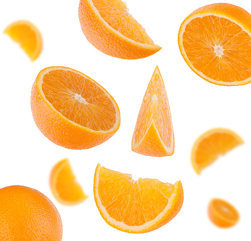 flying sliced orange fruit segments   isolated on white