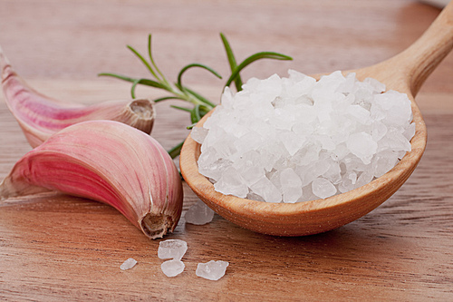 Fresh herbs and salt spoon on vintage wooden background. Shallow focus.