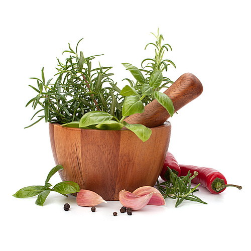 fresh flavoring herbs and spices in wooden mortar isolated on white