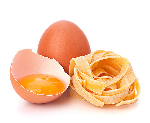 Italian egg pasta fettuccine nest isolated on white
