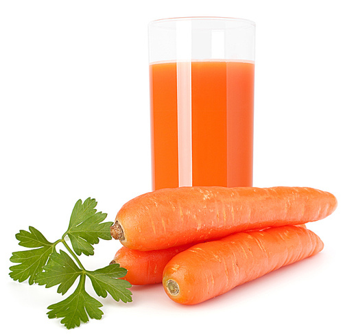 Carrot juice glass and carrot tubers isolated on white