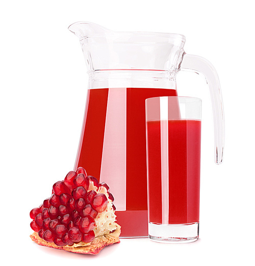 Pomegranate fruit juice in glass pitcher isolated on white cutout