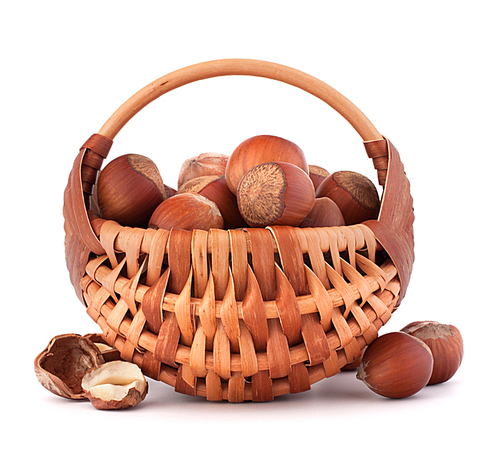Hazelnuts in wicker basket isolated on white