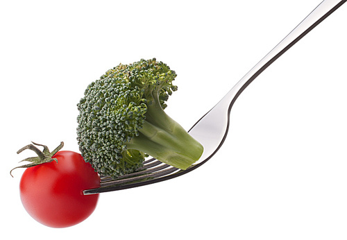 Fresh raw vegetables on fork isolated on white cutout. Healthy eating concept.