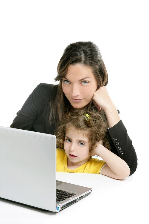 Beautiful mother and daughter with laptop computer on white background