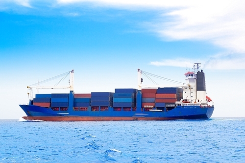 cargo ship with containers in dep blue ocean sea