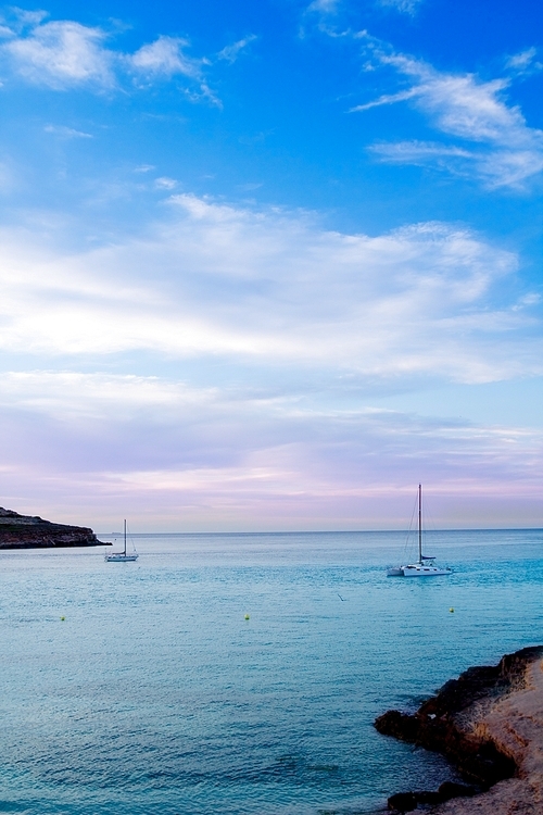 Ibiza cala Conta Conmte sunset with catamaran sailboat