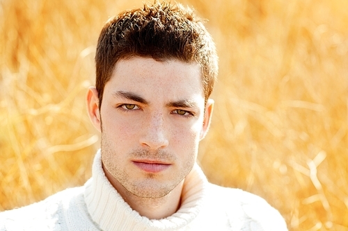 Autumn winter man portrait in outdoor dried grass field with turtleneck sweater