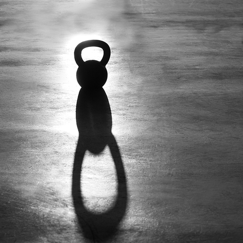 Crossfit Kettlebell weight backlight and shadow on the gym floor