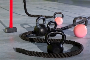 Crossfit Kettlebells ropes and hammer in fitness gym floor
