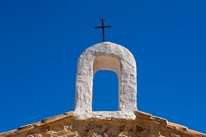 Christian cross on whitewashed arch at village church in Cuenca Spain