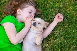 Blond happy girl with her chihuahua doggy portrait lying on lawn