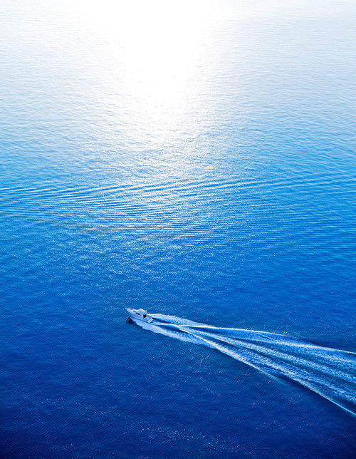 Boat cruising blue Mediterranean sea aerial view in Spain