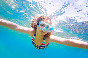 snorkeling blond kid girl underwater with goggles and swimsuit in Mediterranean sea