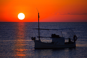 Ibiza sunset  view and menorquina fisherboat from Formentera orange sky