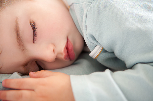 baby toddler sleeping closed eyes relaxed in soft blue